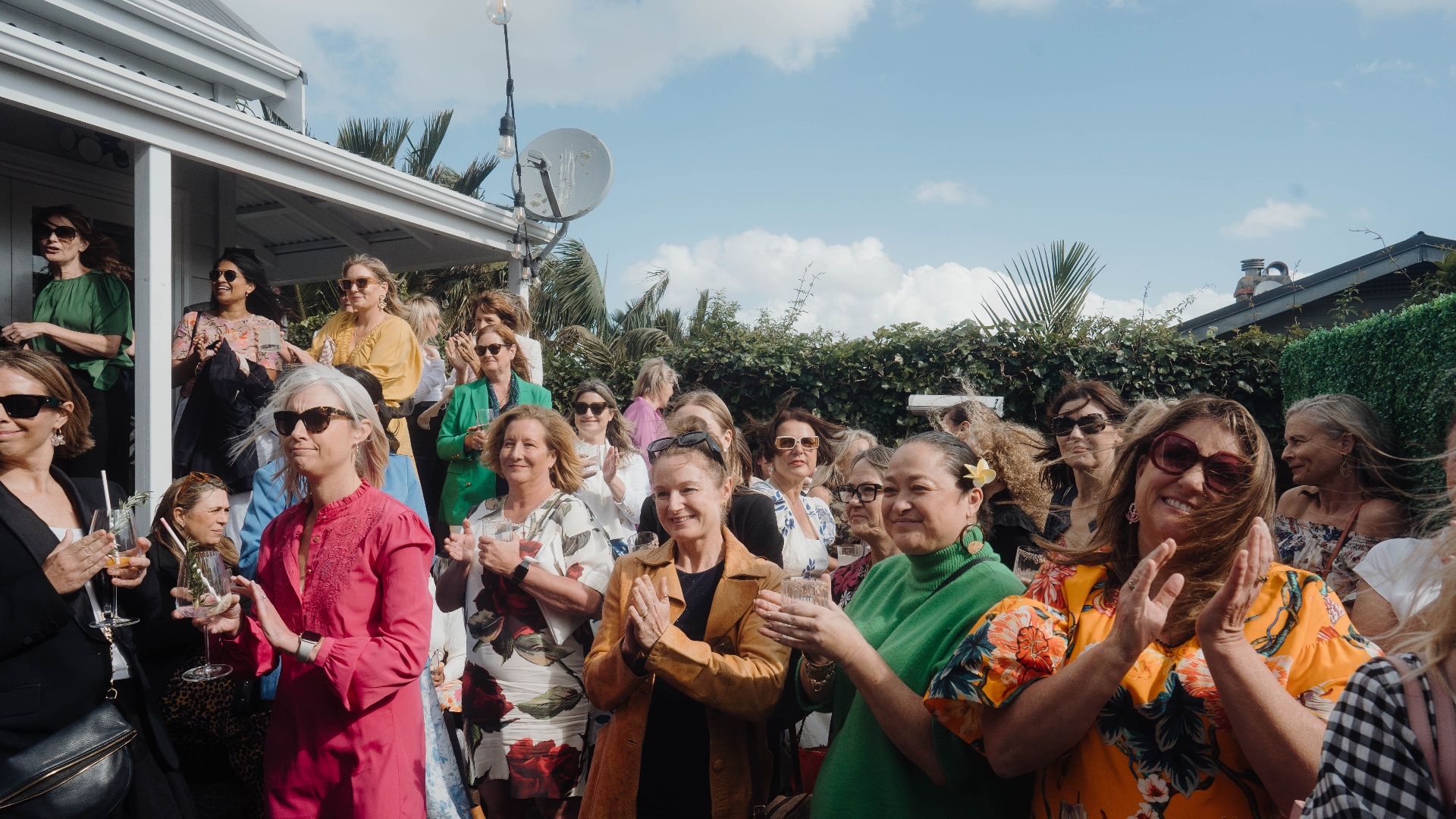 Members applauding at the garden party